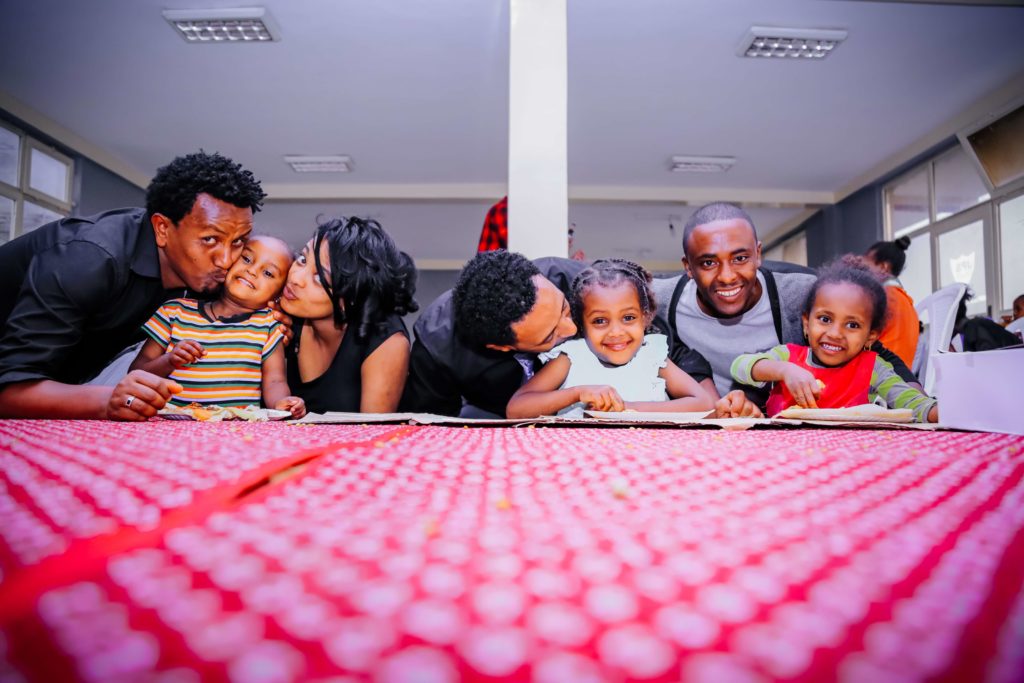 families kissing and hugging their children